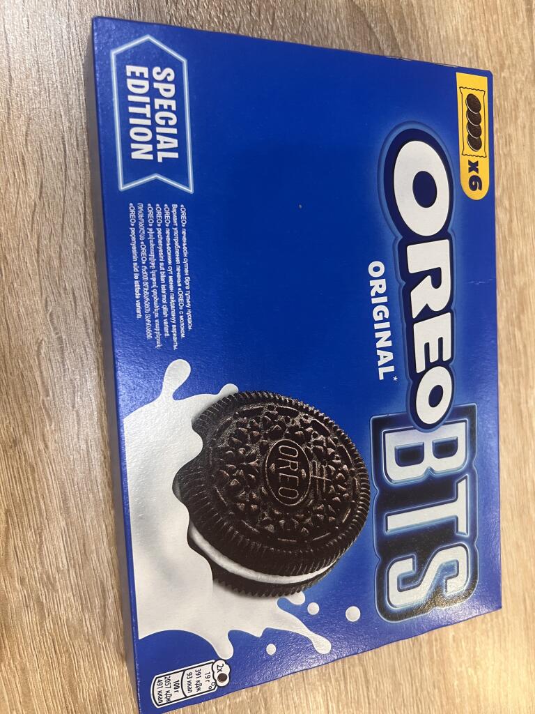 Синяя коробка OREO BTS Special Edition с изображением печенья в молоке на деревянном столе