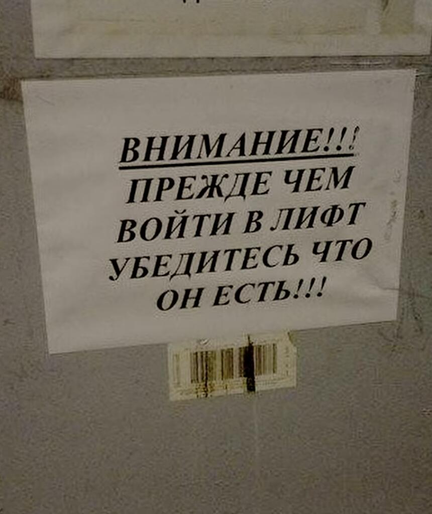 Бумажное объявление на стене с текстом: ВНИМАНИЕ!!! ПРЕЖДЕ ЧЕМ ВОЙТИ В ЛИФТ УБЕДИТЕСЬ ЧТО ОН ЕСТЬ!!!