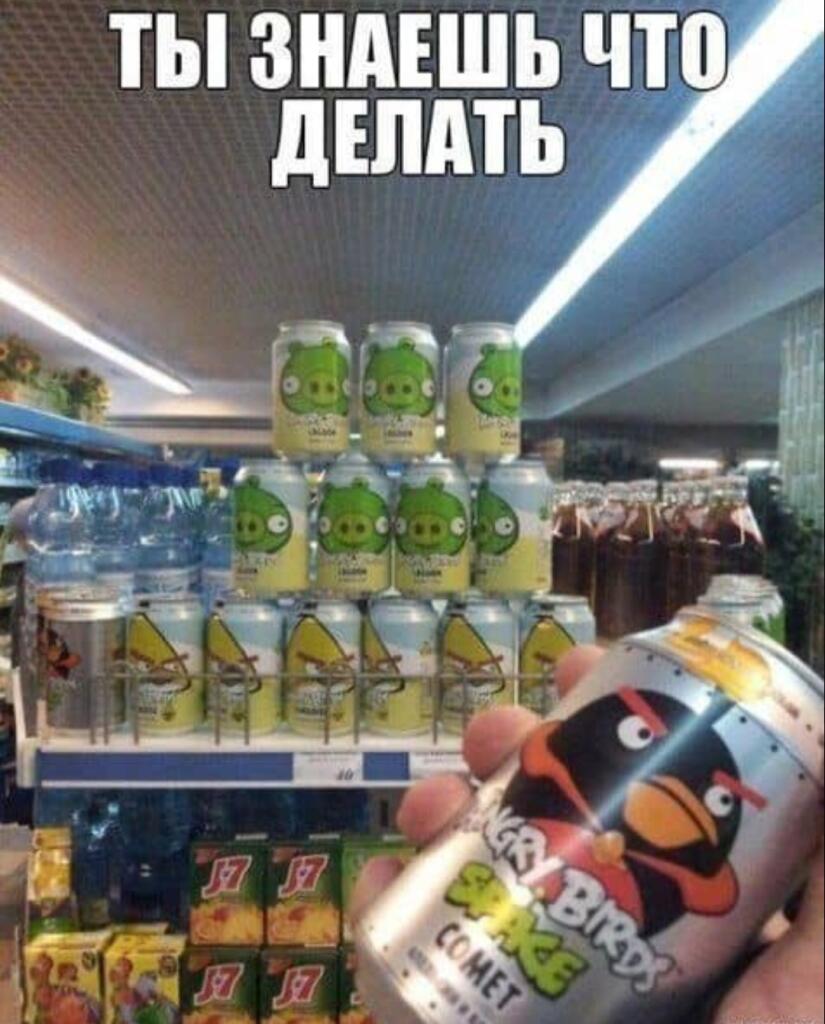 Человек держит банку энергетика Angry Birds Comet на фоне стеллажа с другими банками из этой серии, надпись «Ты знаешь что делать