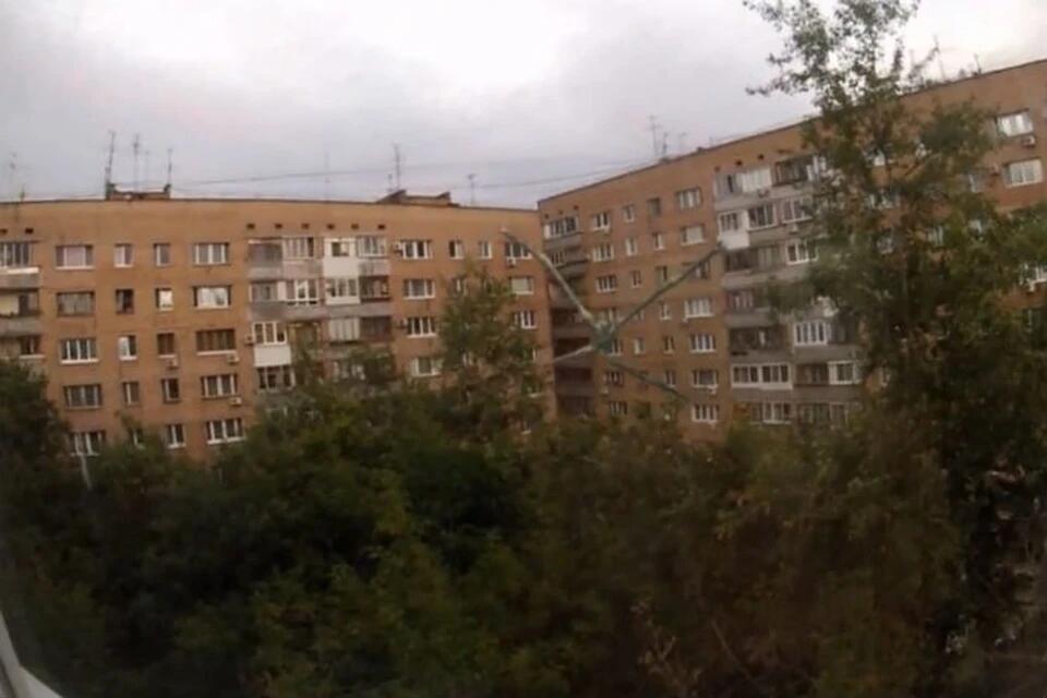 Типовой жилой дом с деревьями на фоне пасмурного неба снят под наклоном