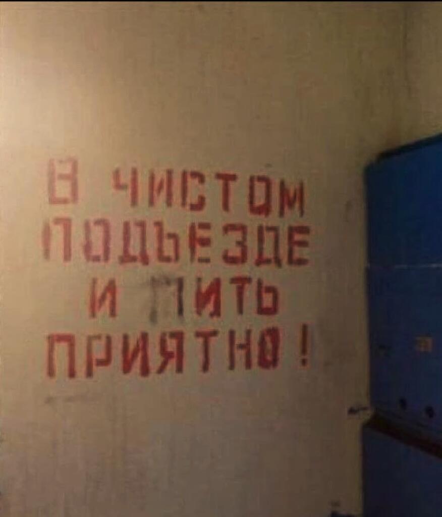 Красная трафаретная надпись на стене подъезда: В ЧИСТОМ ПОДЪЕЗДЕ И ПИТЬ ПРИЯТНО!